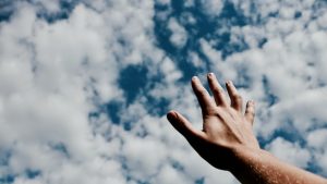 空に向かって手をかざす様子