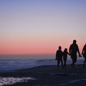 海岸を歩く家族の影
